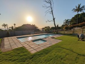 a swimming pool in a yard with a fence at Rembrandt - Zur See in Ballito +6 photos
