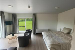 a bedroom with a bed and a table and chairs at Le Grand Pont in Vielsalm
