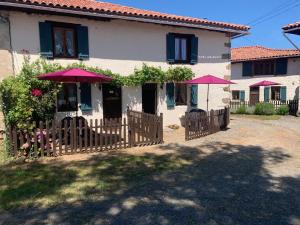 a house with pink umbrellas in front of it at Charming Gite with pool - peaceful coumtryside in Charente in Exideuil