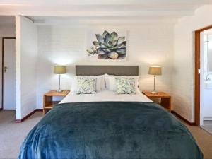 a bedroom with a large bed with two lamps at Stonehedge Cottages in Franschhoek