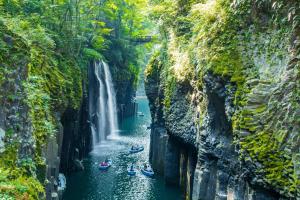 a group of people rafting down a waterfall at ゲストハウスまみむ in Mamihara