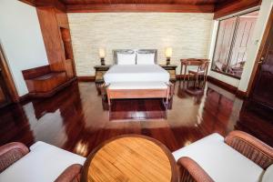 a bedroom with a bed and a table and chairs at El Mar Resort in Sampong