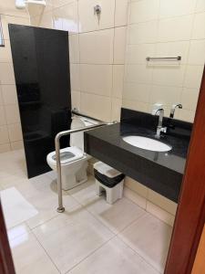 a bathroom with a toilet and a sink at Plaza Hotel in Mineiros