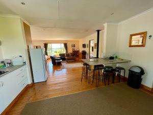 a kitchen and living room with a table and chairs at Bee’s Knees Cottage in Winterton +16 photos