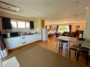 a kitchen and living room with a table and chairs at Bee’s Knees Cottage in Winterton