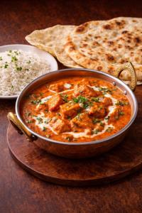 a bowl of curry with rice and a plate of food at Manchester Airport Stanley Hotel by Belvilla in Handforth