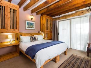 a bedroom with a large bed and a window at TNiqua Stable Inn in Plettenberg Bay