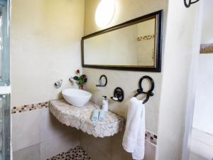 a bathroom with a sink and a mirror at TNiqua Stable Inn in Plettenberg Bay