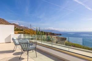 a balcony with two chairs and a view of the ocean at Villa Harmonie in Achlia