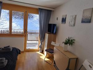 a living room with a view of a balcony at Studio Vitalis in Zermatt