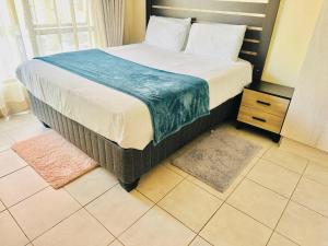 a large bed in a room with two rugs at Druza’s guest house in Rustenburg +29 photos