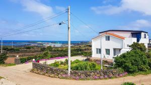 a white house with a view of the ocean at Rabit Island healing house in Jeju