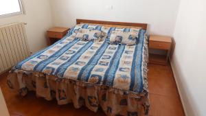 a bedroom with a bed with a blue comforter at 2-Bedroom Chalet for Ski and Summer in Kfardebian