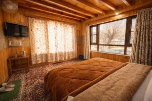 a bedroom with a bed and a large window at Rainbow Palace Pahalgam in Pahalgām