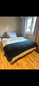 a bed with a blanket on top of a wooden floor at Casa Brekka in Bamble
