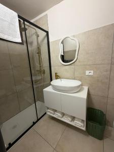 a bathroom with a sink and a shower and a mirror at Casa Bago in Ivrea