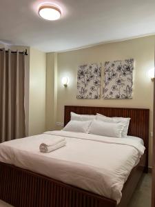 a bedroom with a large bed with two pictures on the wall at Jenn Suites - Nakuru Town in Nakuru +31 photos