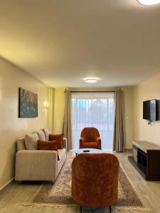 a living room with a couch and two chairs at Jenn Suites - Nakuru Town in Nakuru
