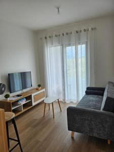 a living room with a couch and a tv at Friendly & Warm in Tamarin