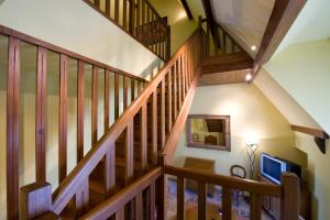 a staircase with wooden railings and a television at Resort Golf Château de Salles in Vezac