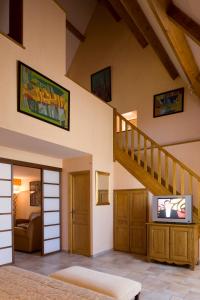 a living room with a staircase and a television at Resort Golf Château de Salles in Vezac