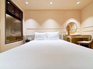 a bedroom with a large white bed and a window at Peace Home Boutique Hotel in Phan Thiet