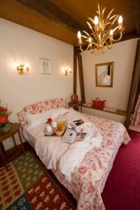 a bedroom with a bed and a chandelier at Resort Golf Château de Salles in Vezac