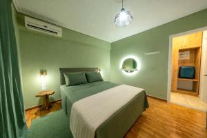 a bedroom with a bed with a green wall at Olive Aura in Mytilene