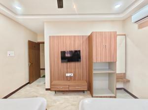 a room with a wooden cabinet with a tv on it at Hotel Sanskar Palace in Godarpura