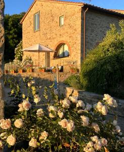 a building with a bunch of roses in front of it at Romantic Apartment With Tuscan Valley Views in Londa