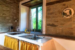 a kitchen with a sink and a stone wall at Romantic Apartment With Tuscan Valley Views in Londa