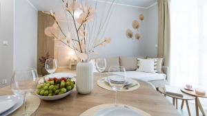 a dining room with a table with a bowl of fruit and wine glasses at Baltic Line - Pomerania in Gdańsk