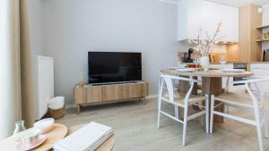a kitchen and living room with a table and a television at Baltic Line - Pomerania in Gdańsk