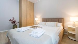 a bedroom with a white bed with towels on it at Baltic Line - Pomerania in Gdańsk