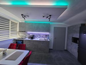 a kitchen with a blue light on the ceiling at Casa MADE in Turda