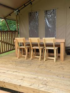 a wooden table and two chairs on a deck at Glampingtent Serengeti in Zwartemeer +2 photos