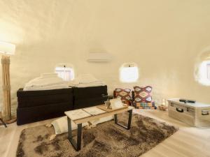 a living room with a bed and a coffee table at Dot Glamping 富士山 in Fujikawaguchiko