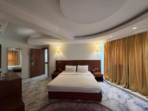 a hotel room with a bed and a large window at Coral Hotel Karbala in Karbala +58 photos