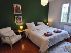 a green bedroom with a large bed and a chair at Ostal del Koï in Rabastens