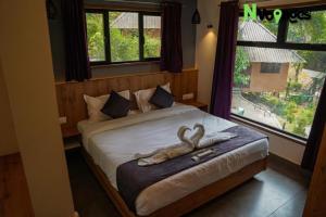 a bedroom with a bed with two swans on it at Nvoyages Wayanad in Wayanad
