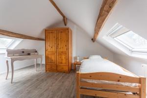 a bedroom with a bed and a desk in a attic at La Ruche - Maison 7p avec Jardin in Saint-Lucien