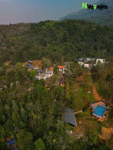 an aerial view of a village in a forest at Nvoyages Wayanad in Wayanad