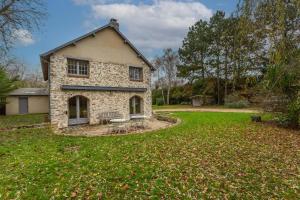 a stone house with a bench in a yard at La Ruche - Maison 7p avec Jardin in Saint-Lucien