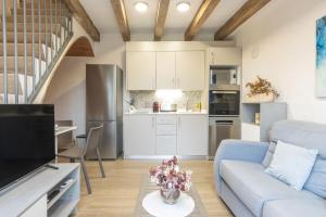 a living room with a blue couch and a kitchen at Mas Pigem in Pals