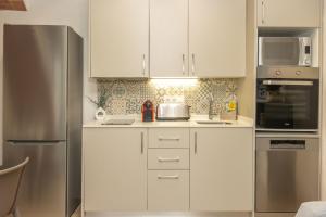 a kitchen with white cabinets and a stainless steel refrigerator at Mas Pigem in Pals +33 photos