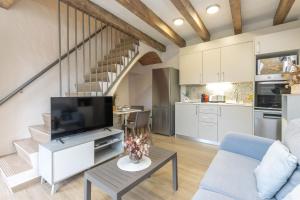 a kitchen and living room with a tv and a staircase at Mas Pigem in Pals