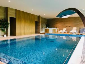 a swimming pool with an umbrella in a house at Hotel Harmonie in Luhačovice