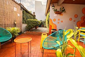 a patio with two chairs and tables and plants at Chillout Hostel Barrio Escalante in San José