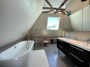 a bathroom with a white tub and a sink and a mirror at Paillé in Artiguelouve +43 photos