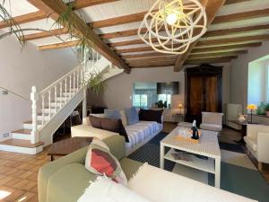 a living room with white furniture and a wooden ceiling at Paillé in Artiguelouve